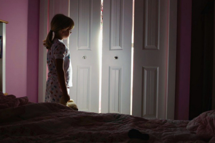 Девочка-лунатик стоит в комнате у двери