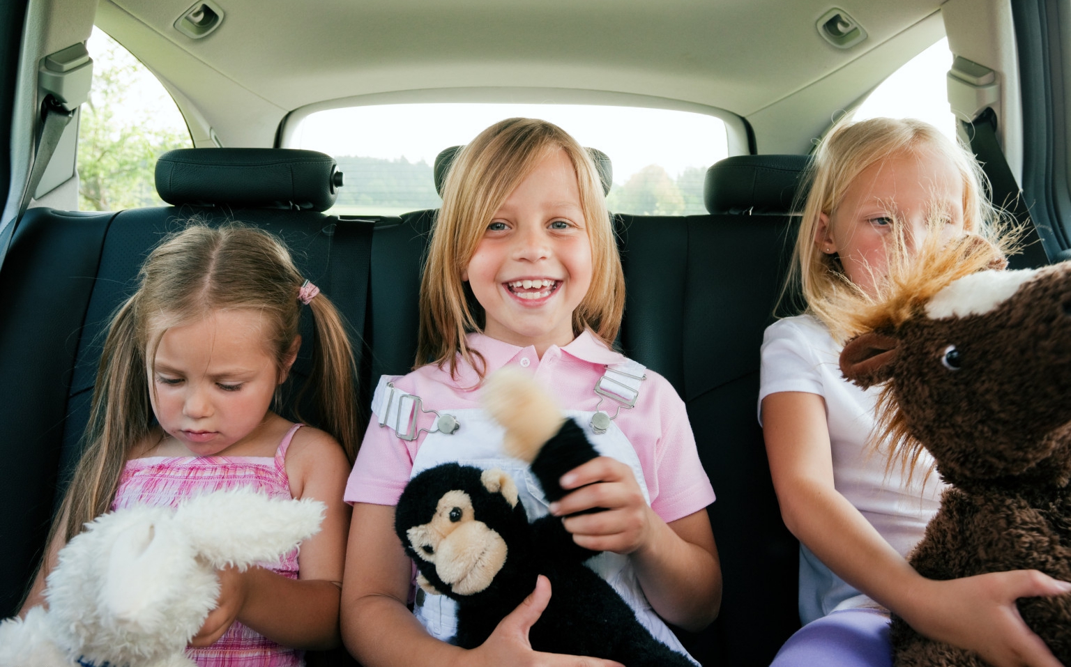Трое детей на заднем сидении авто