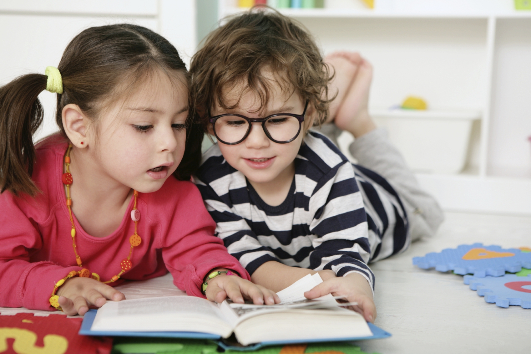Мальчик и девочка рассматривают книгу